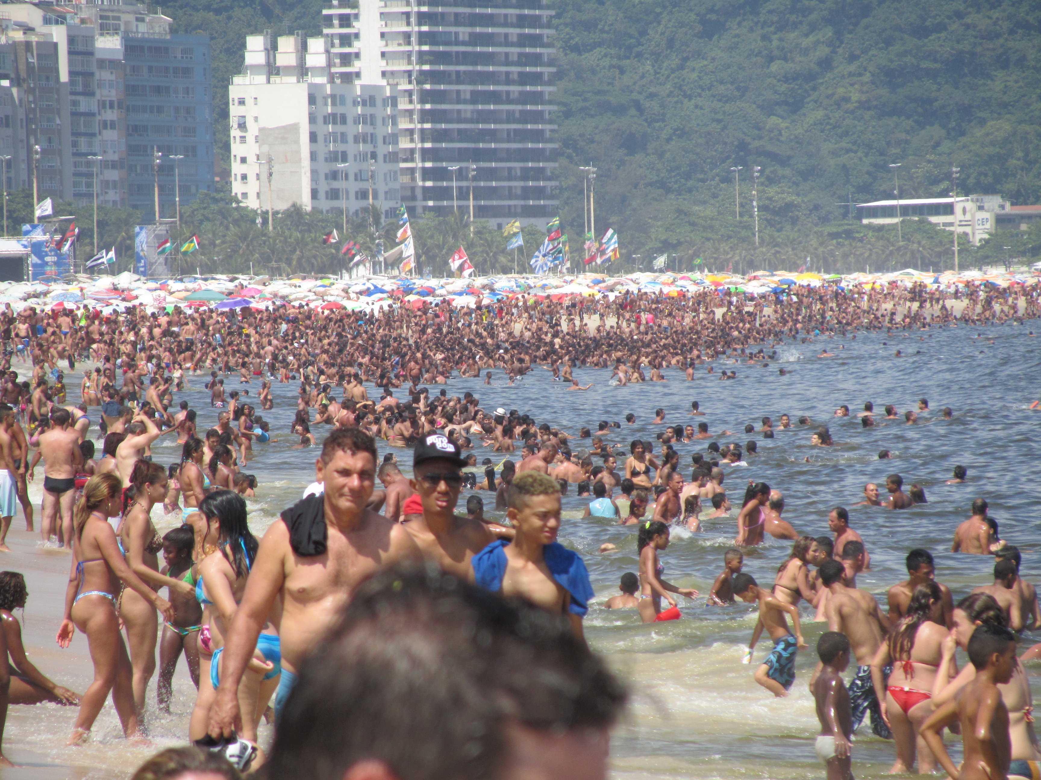 Silvester in Rio de Janeiro tagsüber am Strand 2013: Hunderttausende Menschen genießen an der Copacabana bei 37 Grad Hitze die Kühle des Meers.