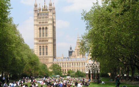 Jugendliche sitzen vor dem britischen Parlament.