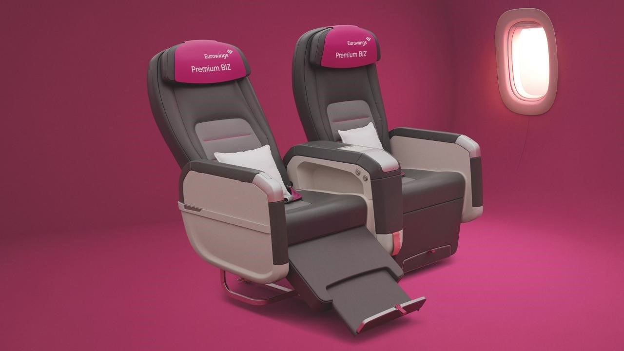 Zwei nebeneinander stehende Premium-BIZ-Sitze von Eurowings mit ausgefahrener Beinauflage, Kopfstützen mit Schriftzug Premium BIZ und einem Kabinenfenster im Hintergrund.