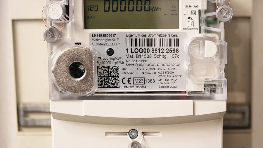 Nahaufnahme eines modernen digitalen Stromzaehlers mit Display, Barcode und Typenschild an einer Zaehlertafel