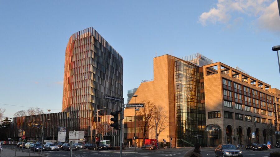 Das Bürogebäude Westarkade der KfW in Frankfurt am Main an der Kreuzung Bockenheimer Landstraße und Senckenberganlage, daneben ein weiteres Bürohochhaus, aufgenommen bei Abendlicht