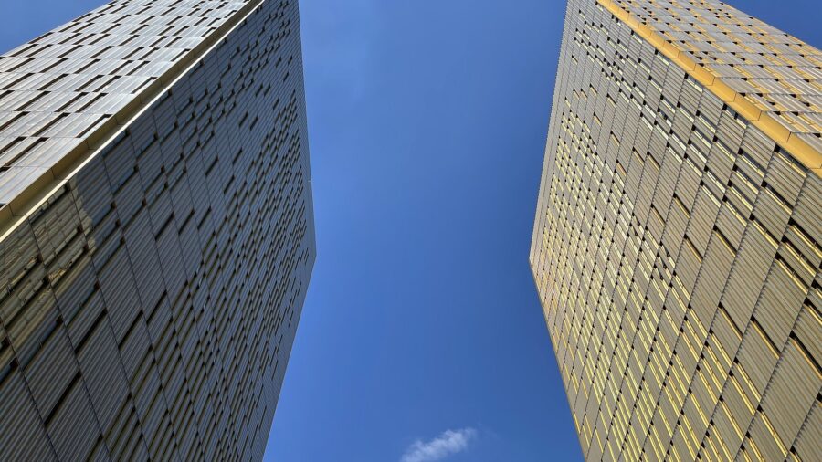 Die beiden goldfarbenen Tuerme des Gerichtshofs der Europaeischen Union in Luxemburg aus der Froschperspektive vor blauem Himmel.