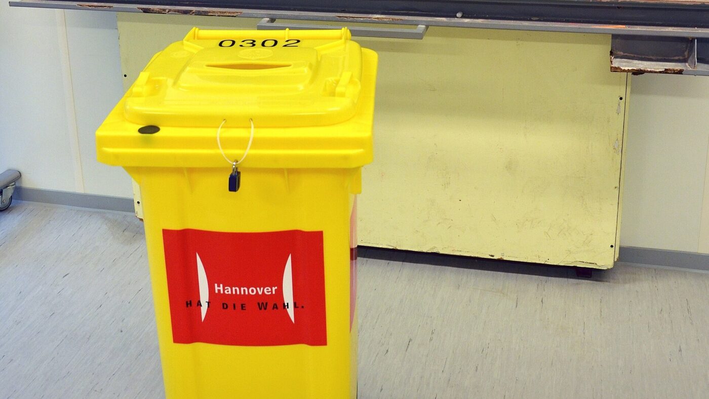 Versiegelte gelbe Wahlurne mit der Nummer 0302 und dem Aufdruck Hannover hat die Wahl in einem als Wahlraum genutzten Klassenzimmer