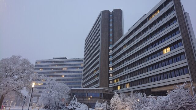 Die verglasten Hochhausriegel der Zentrale der Bundesagentur für Arbeit in Nürnberg bei Schneefall in der Dämmerung