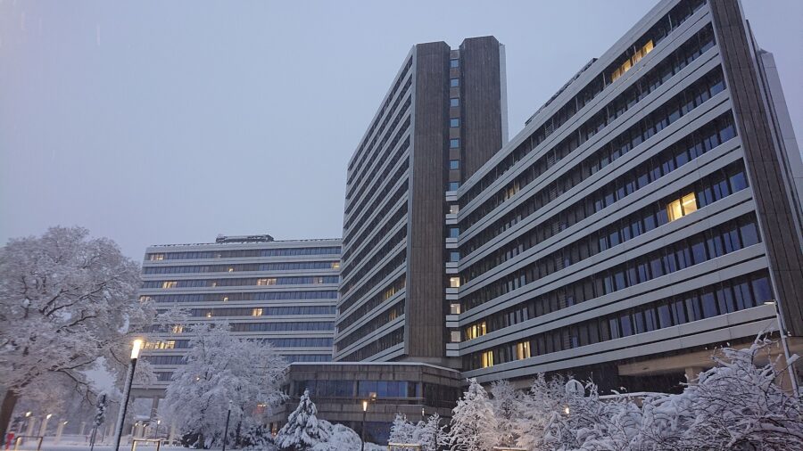 Die verglasten Hochhausriegel der Zentrale der Bundesagentur für Arbeit in Nürnberg bei Schneefall in der Dämmerung