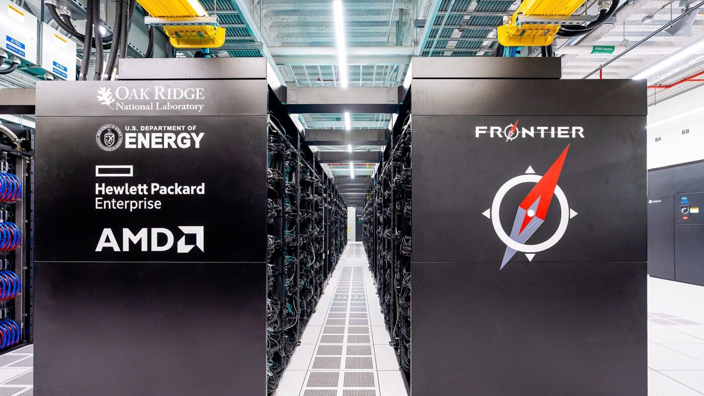 Zwei schwarze Schrankreihen des Supercomputers Frontier in einer Rechenzentrumshalle, beschriftet mit den Logos von Oak Ridge National Laboratory, US-Energieministerium, Hewlett Packard Enterprise und AMD.