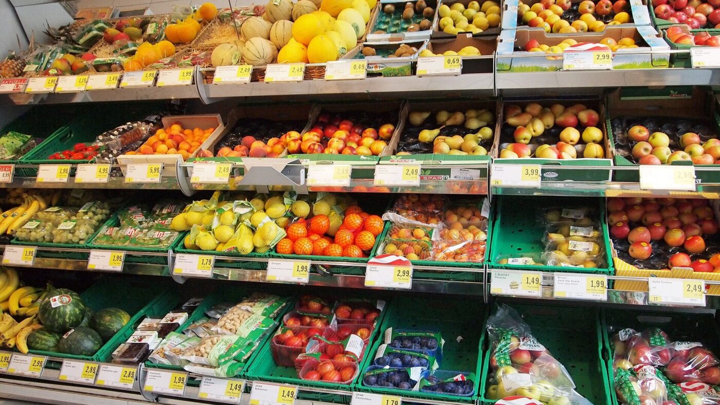 Regale mit Obst und Gemüse und gelben Preisschildern in einem österreichischen Supermarkt