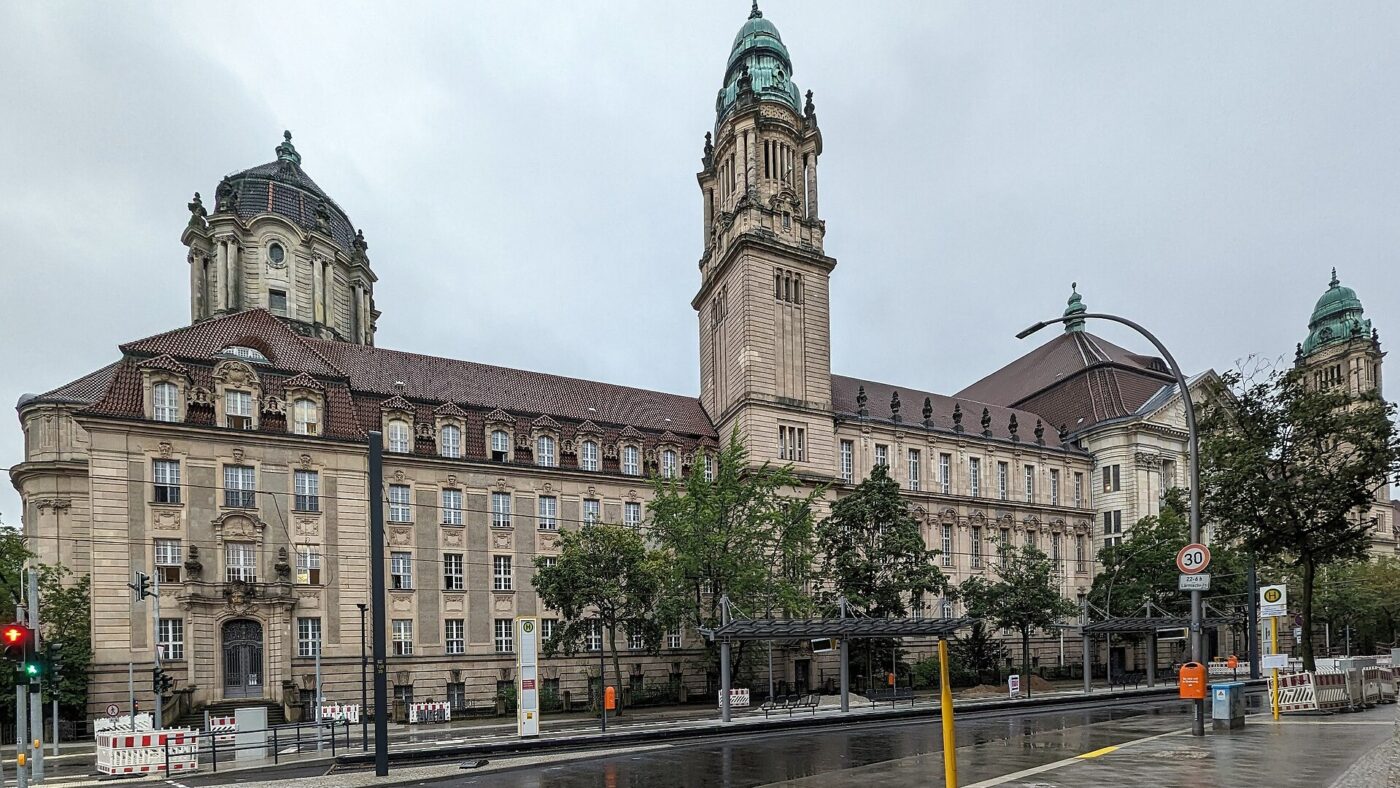 Neobarockes Gerichtsgebaeude des Kriminalgerichts Moabit in der Turmstrasse in Berlin mit Uhrturm und gruenen Kuppeln, davor eine regennasse Strasse
