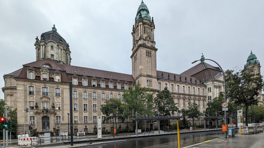 Neobarockes Gerichtsgebaeude des Kriminalgerichts Moabit in der Turmstrasse in Berlin mit Uhrturm und gruenen Kuppeln, davor eine regennasse Strasse