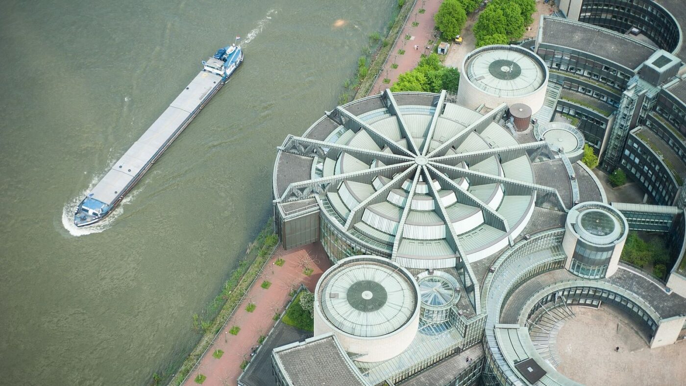 Luftaufnahme des Landtagsgebäudes von Nordrhein-Westfalen mit rundem Dach am Rheinufer in Düsseldorf, links ein Frachtschiff auf dem Rhein