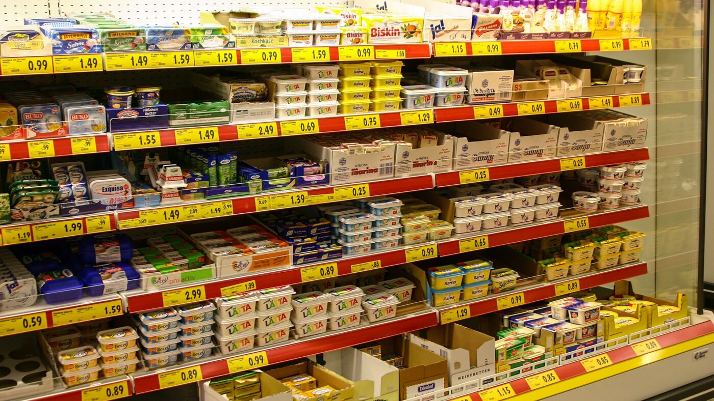 Kuehlregal mit Butter, Margarine, Frischkaese und gelben Preisschildern in einem deutschen Supermarkt
