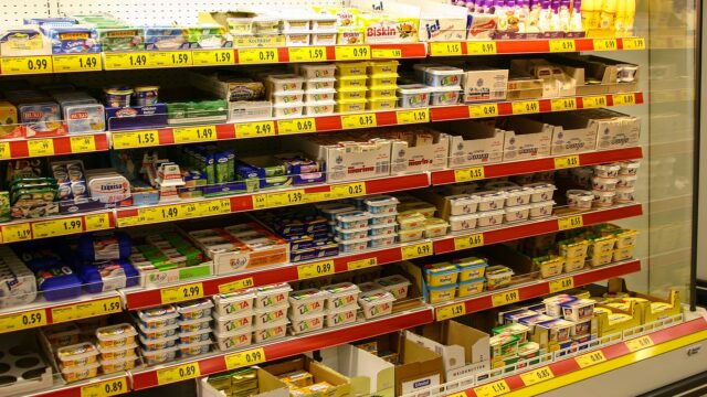 Kuehlregal mit Butter, Margarine, Frischkaese und gelben Preisschildern in einem deutschen Supermarkt