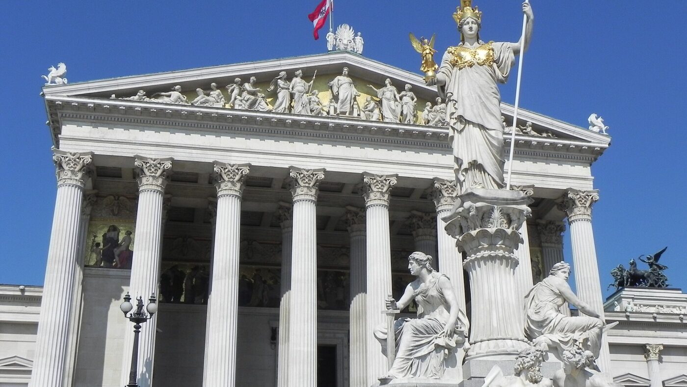 Das Parlamentsgebäude in Wien mit dem Pallas-Athene-Brunnen davor und der österreichischen Fahne auf dem Dach