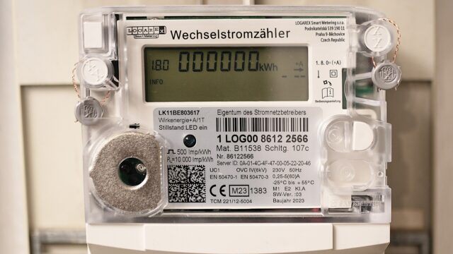Digitaler Wechselstromzähler in einem Zählerschrank, das Display zeigt einen Zählerstand von 000000 Kilowattstunden am Tag des Einbaus.