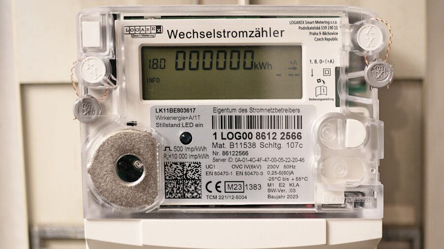 Digitaler Wechselstromzähler in einem Zählerschrank, das Display zeigt einen Zählerstand von 000000 Kilowattstunden am Tag des Einbaus.