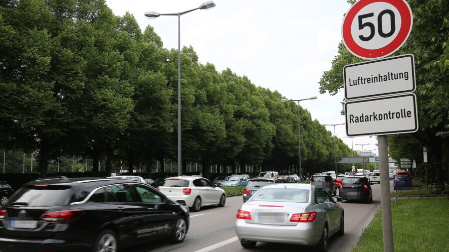 Mehrspurige Straße mit dichtem Autoverkehr in München, am rechten Fahrbahnrand ein Verkehrsschild mit Tempo 50 und den Zusatzschildern Luftreinhaltung und Radarkontrolle.