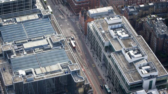 Luftaufnahme mehrerer Bürogebäude beiderseits einer Straße in London