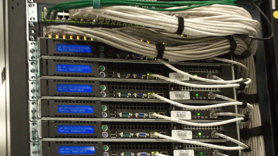 Rückseite eines Serverschranks mit dicht gebündelten Netzwerk- und Stromkabeln in einem Rechenzentrum