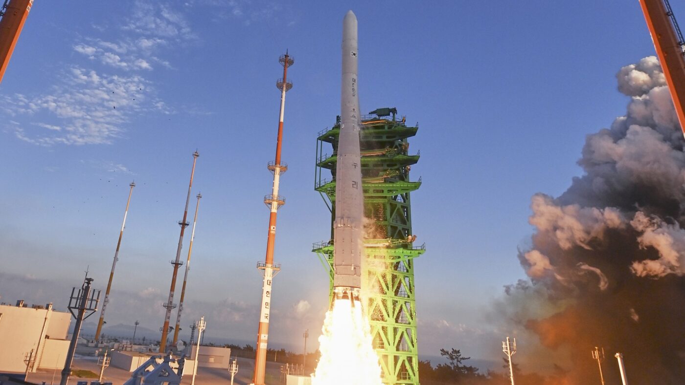 Die südkoreanische Traegerrakete Nuri hebt von der Startrampe des Naro Space Center in Goheung ab, Flammen und Rauch unter der Rakete, blauer Himmel