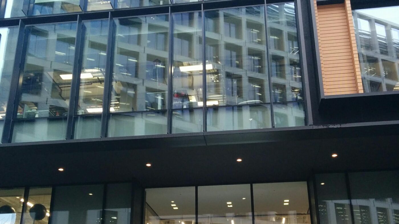 Verglaste Fassade eines modernen Bürogebäudes in London mit mehreren Büroetagen hinter großen Fensterflächen