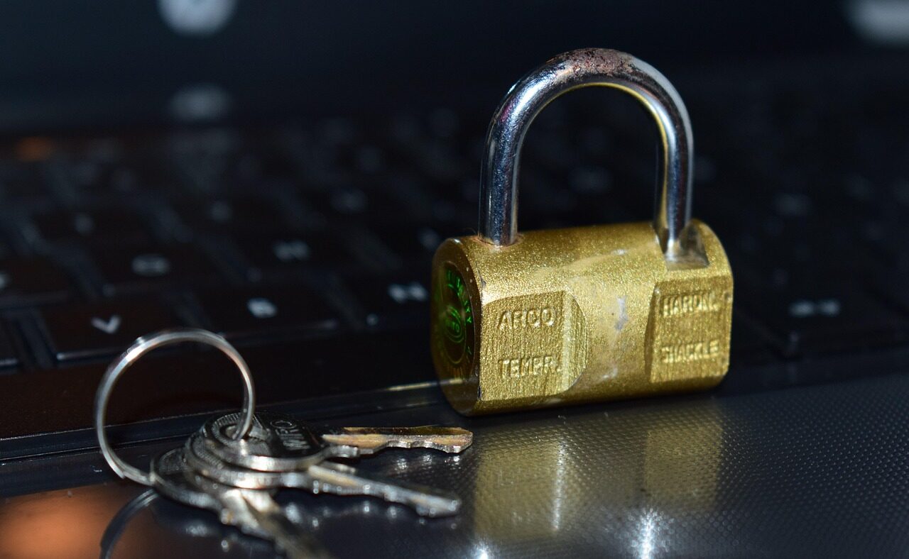 Vorhängeschloss mit Schlüsseln auf einer Computertastatur als Symbolbild für Phishing und Betrug beim Online-Banking