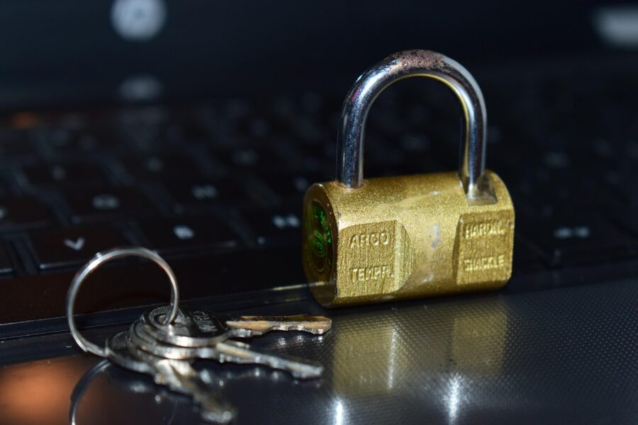 Vorhängeschloss mit Schlüsseln auf einer Computertastatur als Symbolbild für Phishing und Betrug beim Online-Banking