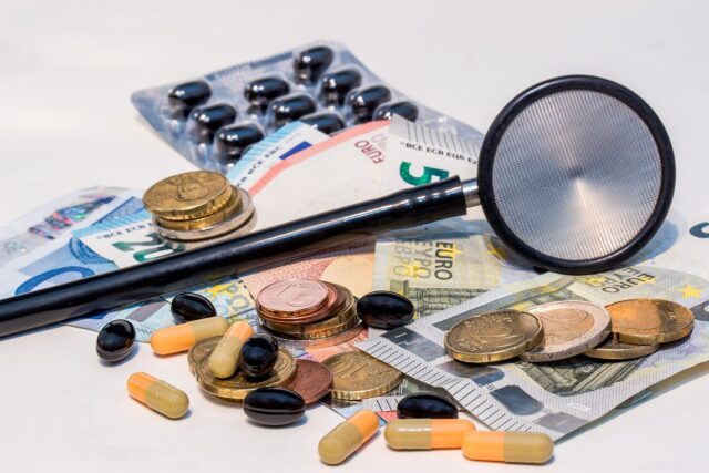 Stethoskop liegt auf Euro-Geldscheinen und -Münzen, Symbolbild zu den Beitragskosten der gesetzlichen Krankenversicherung