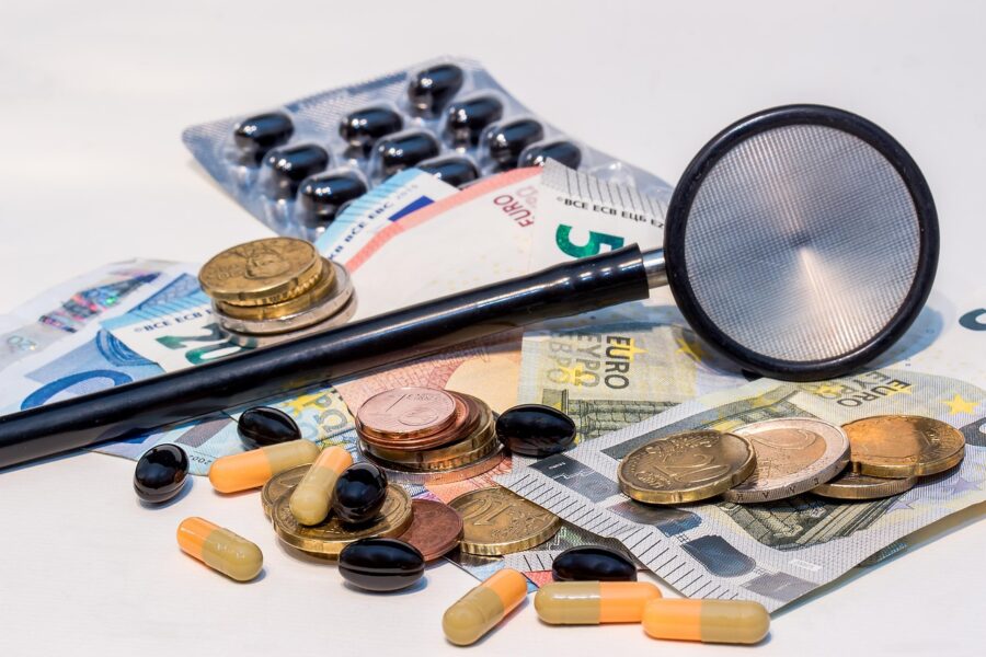 Stethoskop liegt auf Euro-Geldscheinen und -Münzen, Symbolbild zu den Beitragskosten der gesetzlichen Krankenversicherung