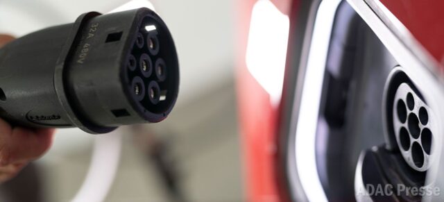 Ein Typ-2-Ladestecker vor dem Ladeanschluss eines Elektroautos.