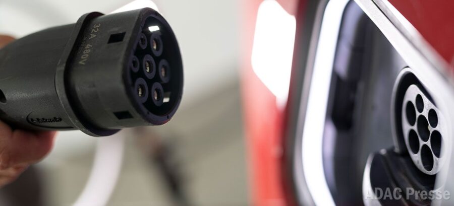 Ein Typ-2-Ladestecker vor dem Ladeanschluss eines Elektroautos.