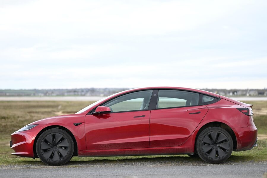 Roter Tesla Model 3 von der Seite fotografiert, Symbolbild zu Tesla Assisted Driving (FSD)